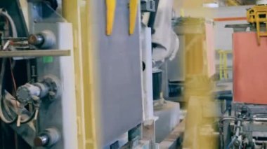 Asılı metal levhalar mekanik olarak taşınıyor.