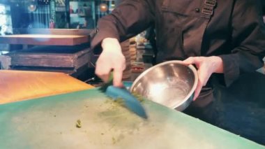 Bir aşçı klozete doğranmış bitkiler atıyor.