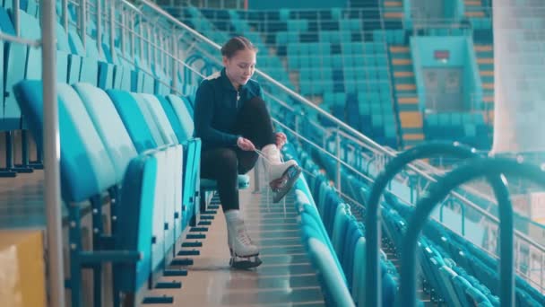 Nona muda mengikat tali sepatu luncurnya di arena olahraga — Stok Video