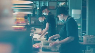 Aşçılar tezgahın arkasında malzemeleri hazırlıyorlar.