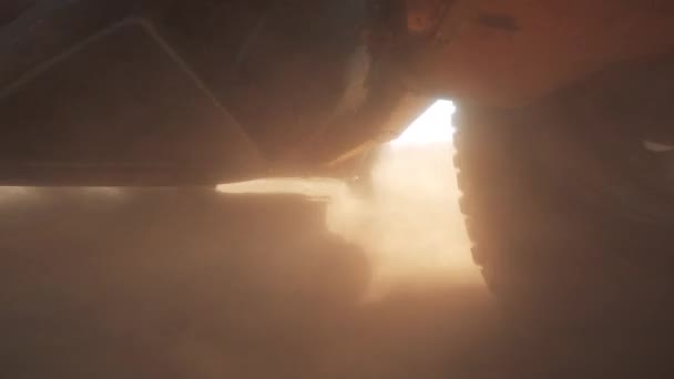Parte inferior de un coche de carreras mientras conduce a través del polvo — Vídeo de stock