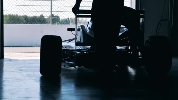 Mechanics are wheeling a racing car out of the garage — Stock Video