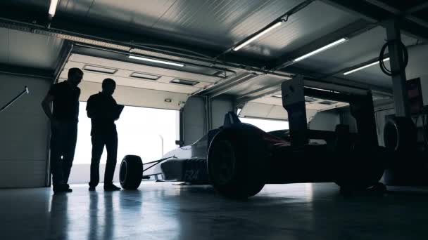 Garage con auto da corsa e due meccanici — Video Stock