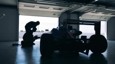 Garaj işçileri bir yarış arabasını tamir ediyor. 4K