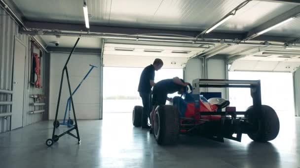 力学はレースカーのキャビンをチェックしています — ストック動画