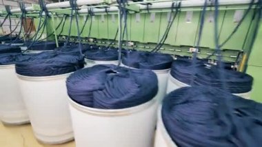 Endüstriyel makineler renkli iplik yığınlarını sersemletiyor.