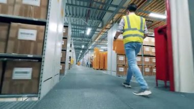 Depo çalışanı plastik kutular taşıyor.