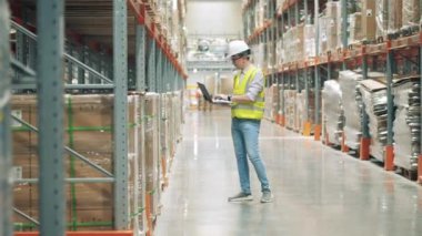 Depoda stok yapan bir erkek işçi var.