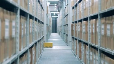 Otomatik depo robotu bir koridorun yanından geçiyor.