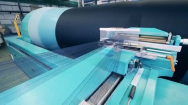 İnce iplikler büyük bir makaradan sarkıyor.