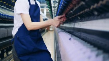 Dikiş makaraları bir fabrika çalışanı tarafından inceleniyor.