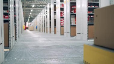 Depo robotu sırtında bir kutuyla geziyor.