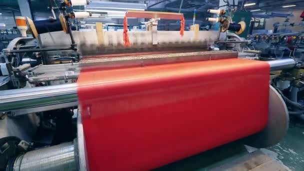 Tela colorida se está tejiendo por la maquinaria de fábrica — Vídeo de stock
