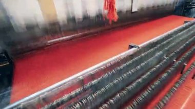 Makine kompleksi parlak renkli kumaş dokuyor.