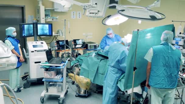 Unité médicale avec un groupe de chirurgiens effectuant une opération — Video