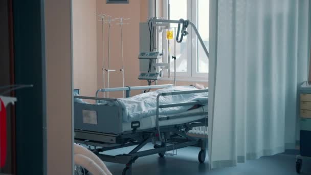 Ιατρικό δωμάτιο με έναν ασθενή ξαπλωμένο πίσω από μια κουρτίνα — Αρχείο Βίντεο