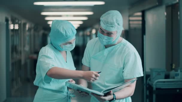 Dua ahli bedah mencari melalui kertas bersama-sama — Stok Video