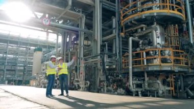 Petrol rafinerisinin boru hatları iki müfettiş tarafından gözleniyor.