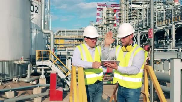 Инженер нефтеперерабатывающего завода рассказывает своему коллеге о проекте — стоковое видео