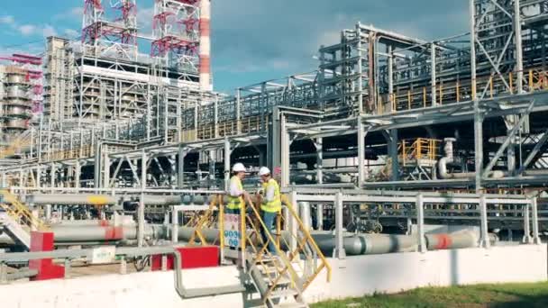 Inspectores de refinería están hablando al lado de un barril masivo — Vídeo de stock