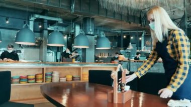 Covid-19 sırasında küçük işletmeler, koronavirüs salgını. Yüz maskesi takan garson restoranları düzene sokuyor.