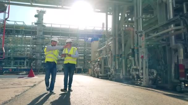 Mannelijke medewerkers lopen door de olieverwerkingsfabriek — Stockvideo