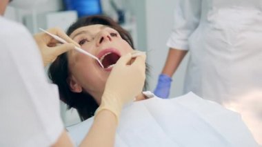 Kadın hasta ağız boşluğuna baktırıyor.