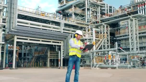 Engenheiro de refinaria está se comunicando através de gadgets nas instalações da planta — Vídeo de Stock