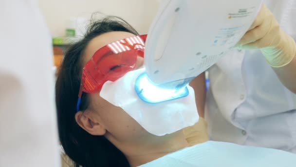 Uma mulher está a fazer um procedimento de higiene oral — Vídeo de Stock