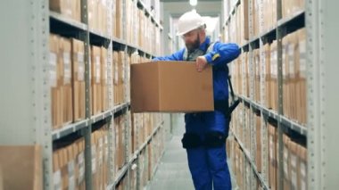 Ergoskeleton 'daki depo çalışanı bir paketin yerini değiştiriyor.