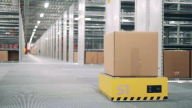 Bir kutu bir robot taşıyıcı tarafından taşınıyor.