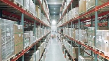 Depo rafları, paketler ve aralarında bir geçit.