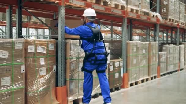 Trabalhador de armazenamento é ergoskeleton está deslocando pacotes — Vídeo de Stock