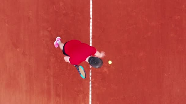 Вид сверху на теннисный корт с мужчиной, подающим мяч — стоковое видео
