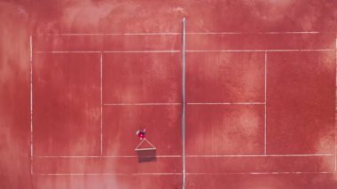 Bir adam tenis ağının yerini sahaya doğru değiştiriyor.