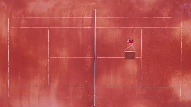 Теннисный корт с человеком, несущим сеть в виде сверху — стоковое видео