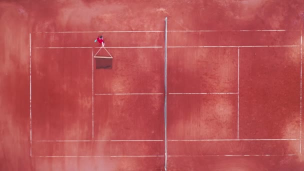 Bovenaanzicht van een tennisbaan met een man die het net verplaatst — Stockvideo