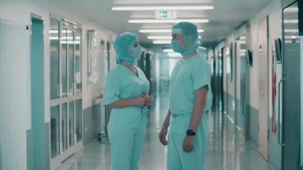 Медицинские сотрудники разговаривают в коридоре — стоковое видео