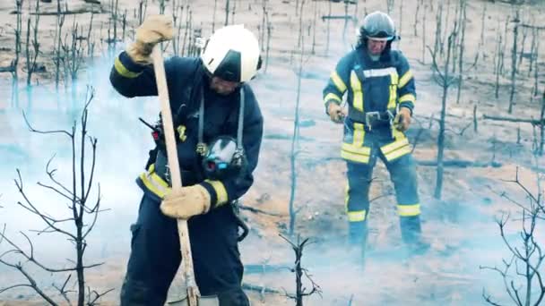 Uitgebrande grond wordt gedempt door de brandweer. — Stockvideo