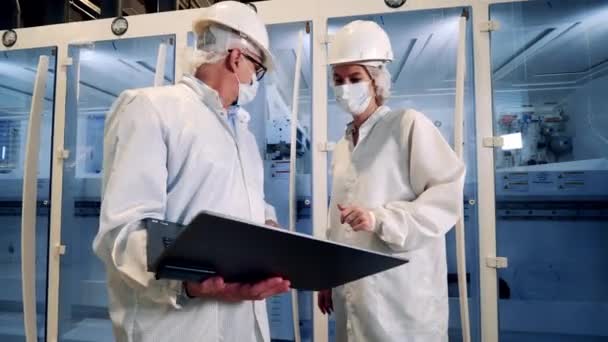 Ingenieurs, teamwork, moderne fabriek. Zonnecelfabriek met twee specialisten die apparatuur observeren — Stockvideo