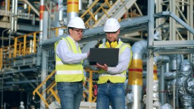 İş ortakları rafineri fabrikasında tartışıyorlar.