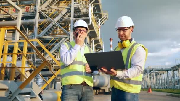 Oilfield ingenjörer i hardhats använder kommunikationsutrustning — Stockvideo