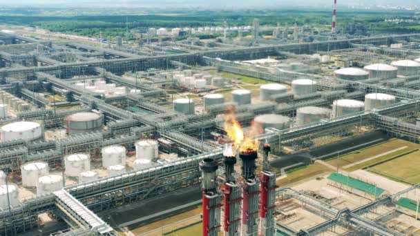 Instalações de refinaria de petróleo com fogo saindo das pilhas de gás — Vídeo de Stock