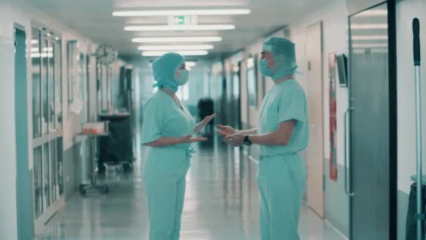 Due medici in uniforme chirurgica stanno parlando nel corridoio — Video Stock