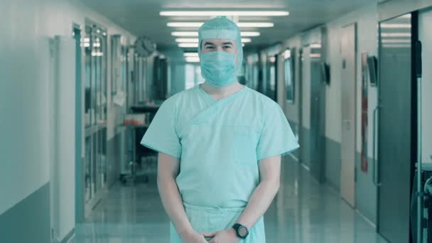 Mužský lékař v operační uniformě se usmívá do kamery — Stock video