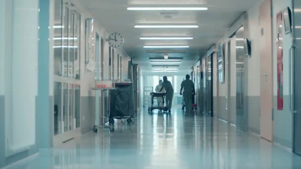 Хирурги катают кровать по коридору больницы — стоковое видео