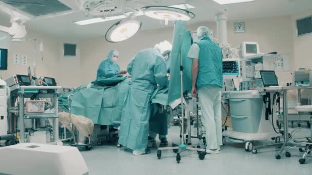 Χειρουργοί εργάζονται σε μια ομάδα, ενώ εκτελεί μια επιχείρηση. Κλινική, νοσοκομείο, ιατρική, χειρουργική έννοια. — Αρχείο Βίντεο