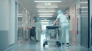 Klinik, hastane, tıp, ameliyat konsepti. İki cerrahın yatağı yuvarladığı hastane koridoru.