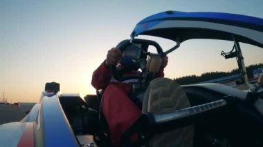 Yarış arabası sürücüsü pistte bir go-cart sürüyor.