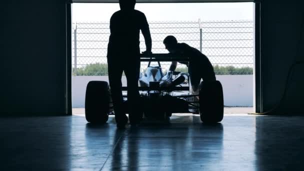 Racing car is getting wheeled into the workshop — Stock Video